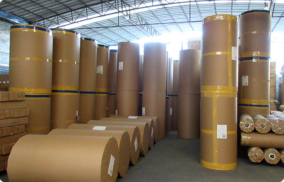 Bulk fabric rolls wrapped in brown paper stacked in the AISNUG warehouse