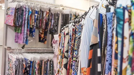 Finished custom-printed garments hanging on rails in the AISNUG sample room